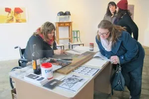 Ms. Schneider (left) was on-hand in the gallery that day, creating images-on-demand and discussing the limitations on her video project incurred by her recently broken leg