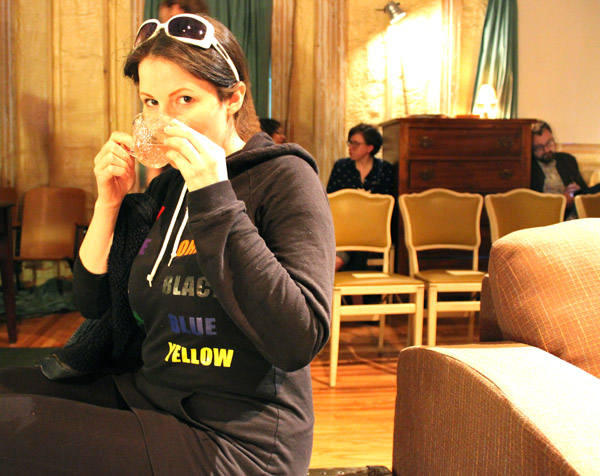 Audience member, artist Corrie Baldauf, enjoys some punch in her seat.