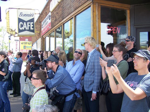 Across the street from the billboard, the waiting crowd gathers in front of The Dubliner.