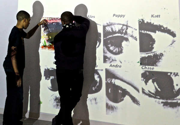 Some of the teen participants working to trace their own eyes onto canvas.