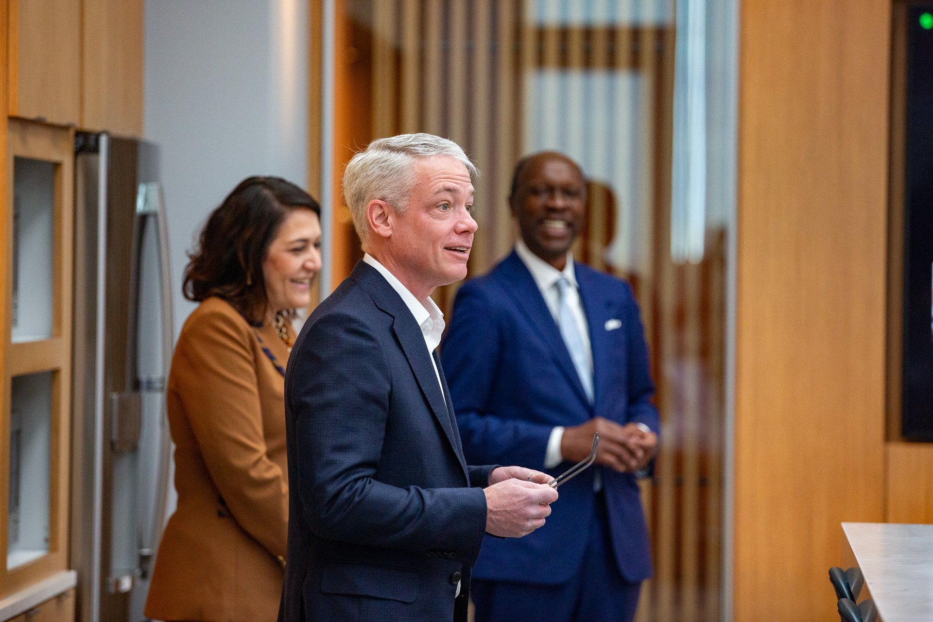 Chris Austen stands in front of Maribel Pérez Wadsworth and Frank Borges.